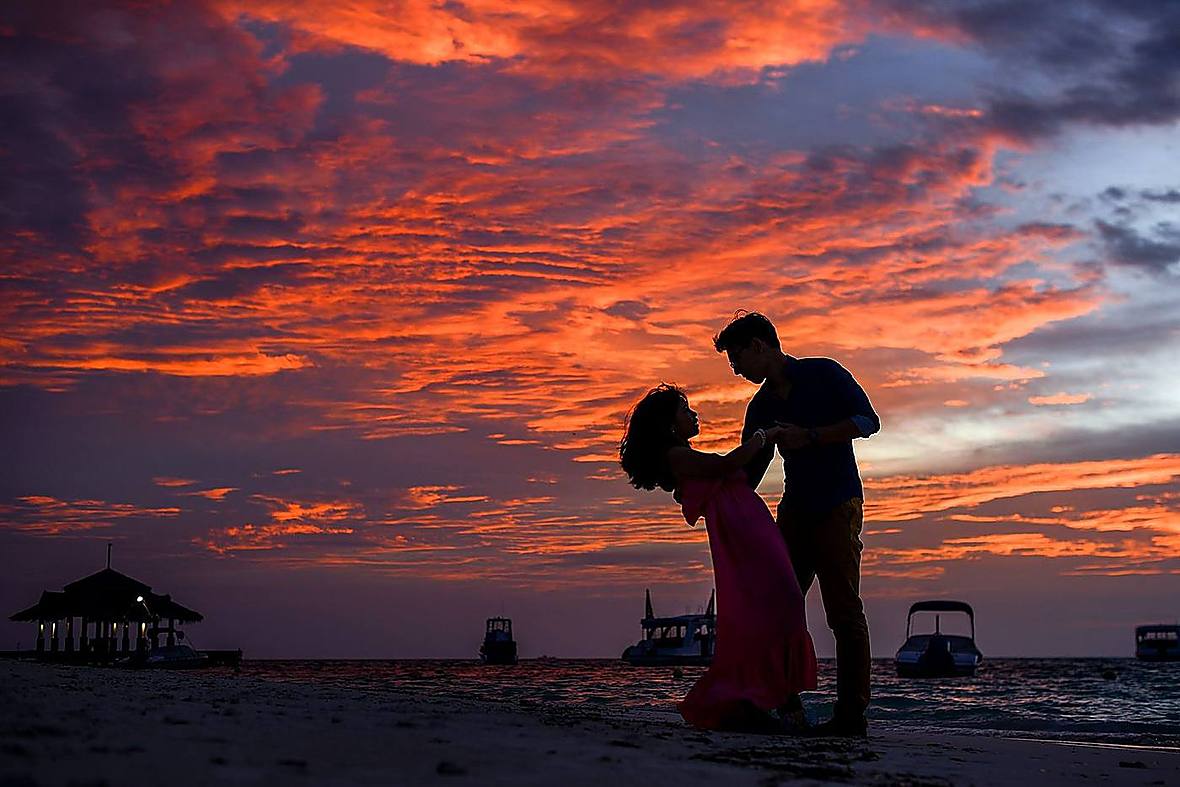Couple silhouette against an ocean sunset